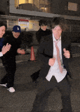 a man wearing a la hat is dancing in front of a sign that says parking