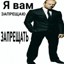 a man in a suit and tie is standing in front of a white background with russian writing