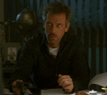 a man is sitting at a desk with the word interesting written on the screen