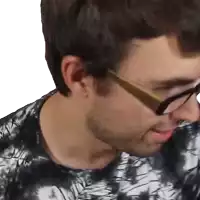 a close up of a man wearing glasses and a tie dye shirt .