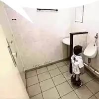 a little boy urinating in a public restroom with ocean-bener written on the corner