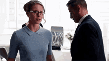 a man and a woman are standing next to each other in a room .