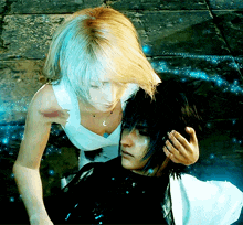 a woman in a white top is standing next to a man with dark hair
