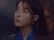 a close up of a woman 's face in a dark room looking up .