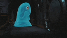 a blue monster with one eye is standing in a dark room ..