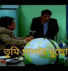 a man in a suit is talking to another man in front of a globe that says ' tumi ' on it
