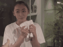 a woman wipes her face with a white towel with the letter b on it
