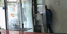 a man stands in front of a glass door with a sign that says no smoking