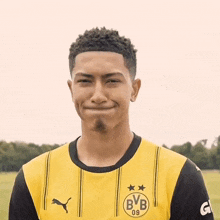 a young man wearing a yellow jersey with bvb on it