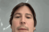 a close up of a man 's face with a mustache
