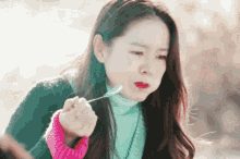 a woman is eating something with a spoon in her hand .