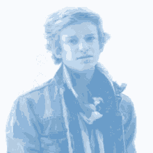 a young man wearing a scarf and a jacket looks at the camera