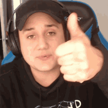 a man wearing headphones is giving a thumbs up sign