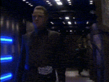 a person is standing in front of a blue light on a wall .