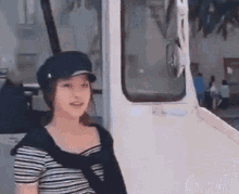 a woman wearing a black hat is standing in front of a white truck .