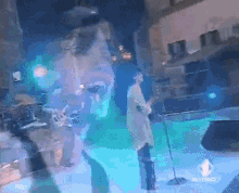 a man singing into a microphone on a stage with a reflection of a man 's face