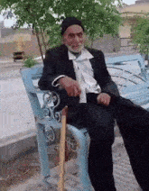 an elderly man is sitting on a bench with a cane