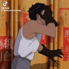 a man in a white tank top is covering his face with his hand .