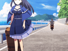 a girl in a blue dress is walking down a road next to a man on a scooter