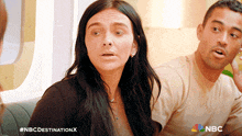 a man and a woman are sitting next to each other with a nbc destination x logo on the bottom