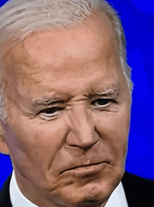 a closeup of a man 's face with a blue background