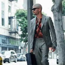 a man in a suit is walking down the street