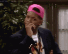 a man wearing a pink hat and a jacket is thinking .