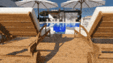a wooden deck with chairs and umbrellas and a swimming pool in the background