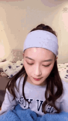 a woman wearing a headband and a sweater that says ' ny we ' on the front