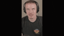 a man wearing headphones and a black shirt is making a face .