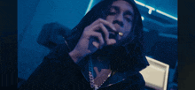 a man smoking a cigarette with a blue background