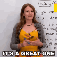 a woman standing in front of a white board with the words it 's a great one on it