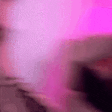 a blurry picture of a person 's face with a pink background