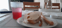 a plate of food on a table with a cup of liquid in the background