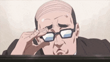 a bald man wearing glasses is sitting at a desk with his hand on his eye .