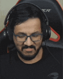 a man wearing glasses and headphones is clapping his hands