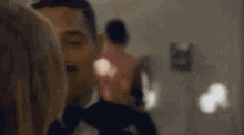 a man in a tuxedo is looking at a woman 's face .