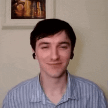 a man in a striped shirt is smiling with his eyes closed