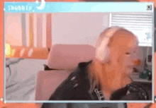 a woman wearing headphones is sitting in front of a computer screen .
