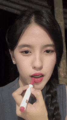 a woman is applying red lipstick with a marker that says 20