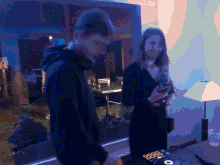 a man and a woman are standing in front of a dj controller that says 8888 on it