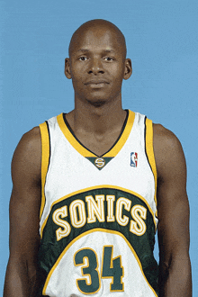 a man wearing a sonics jersey number 34 poses for a picture