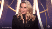 a woman speaking into a microphone with the hashtag #goldenglobes on the bottom