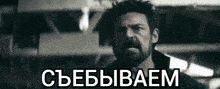 a man with a beard is standing in front of a sign that says ' cbebwaem ' on it