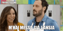 a man and a woman are standing next to each other in a kitchen and the man is saying trash italiano