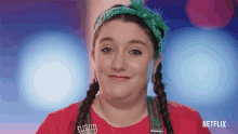 a woman wearing a red shirt and a green bandana has a netflix logo on her shirt