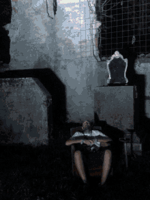 a man is sitting in a chair with his eyes closed in a dark room