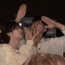 a man and a woman are playing with their hands up in the air
