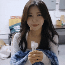 a woman is holding a fork and spoon in her hands