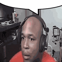 a bald man wearing headphones and a red shirt